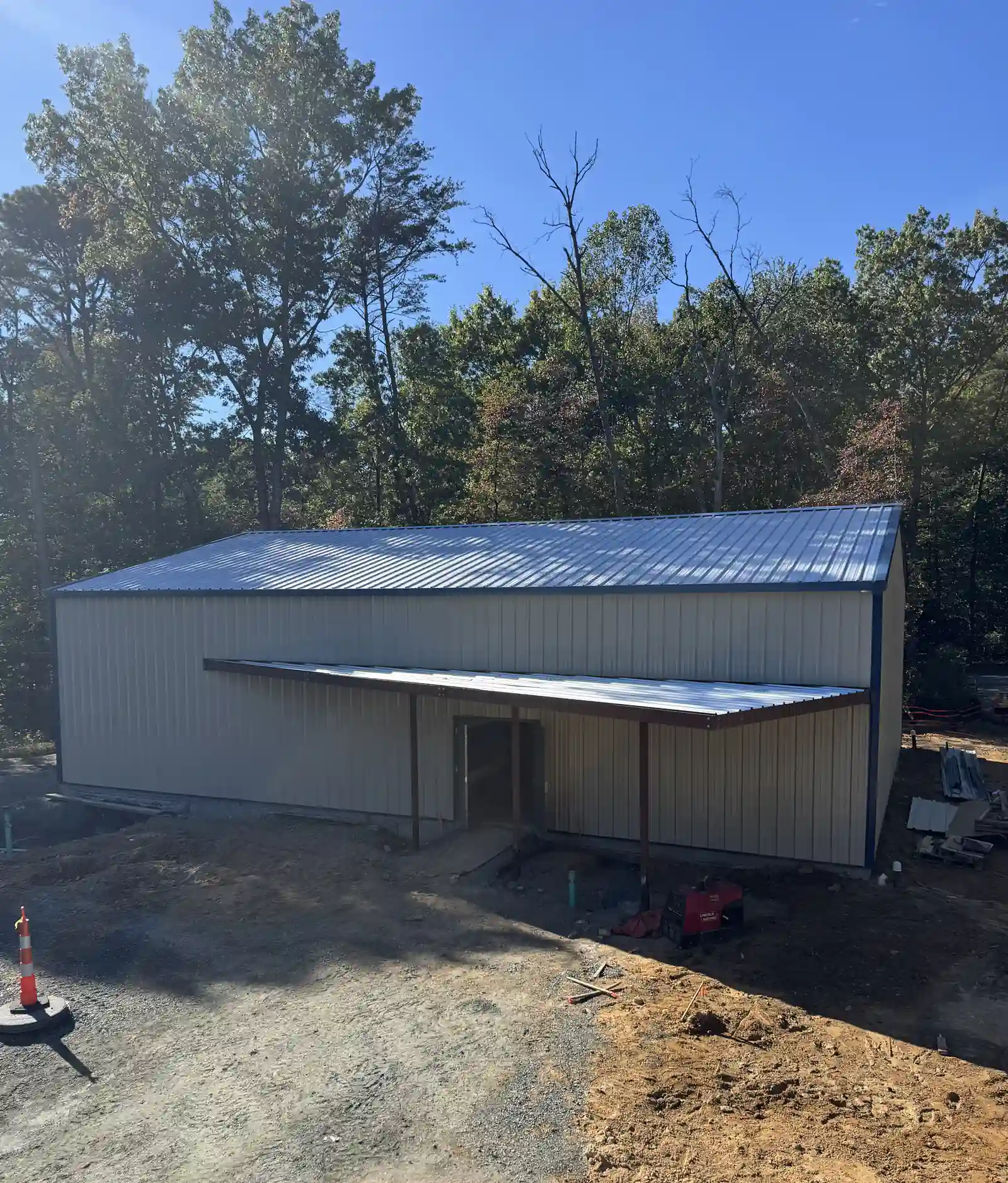 Finished gable end of a steel building with metal wall panels, trim and entry canopy